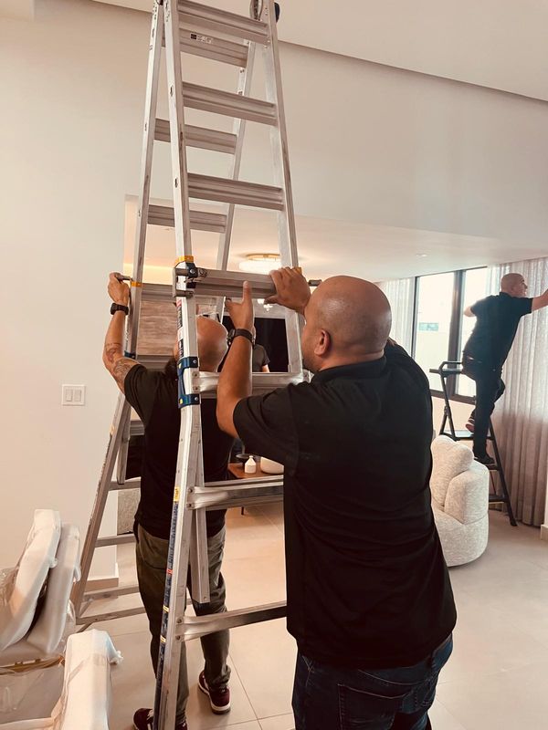 Equipo de WPro instalando cortinas con escaleras