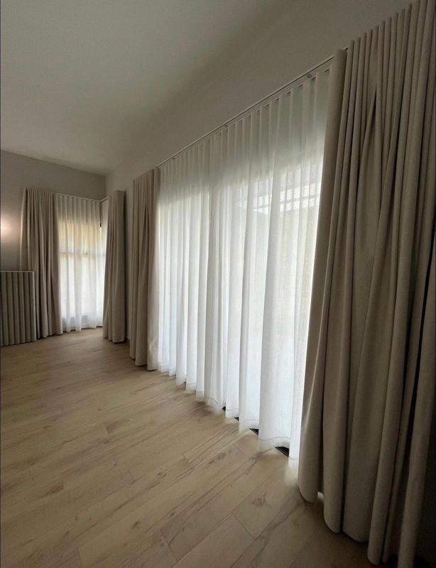 Cortinas de lino y visillo instaladas a lo largo de ventanales